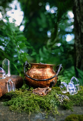 Frog, quartz crystals, spell book, witch cauldron in forest, nature background. fantasy nature image. magic crystal ritual. witchcraft. enchanted, dreams, mystery, fairytale concept