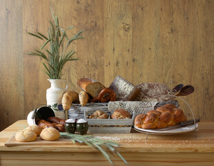 Traditional bakery products number 4 in an organized composition. Bread, loaves, rolls, croissants, pretzels, challah, ears of grain, baked goods, porcelain jug, wooden spoons, traditional decoration