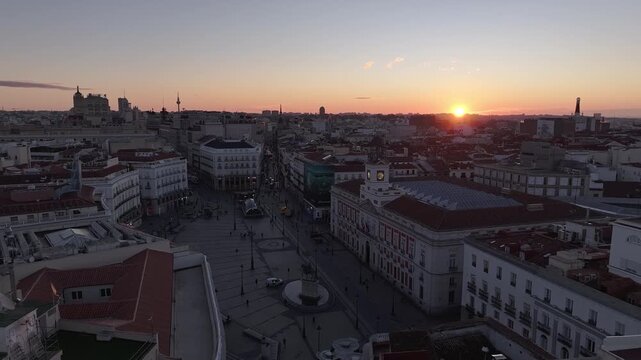 Aerial view of Puerta del Sol square bathed in the warm glow of the setting sun, casting long shadows across the urban landscape, Madrid, Puerta del Sol, Spain.
