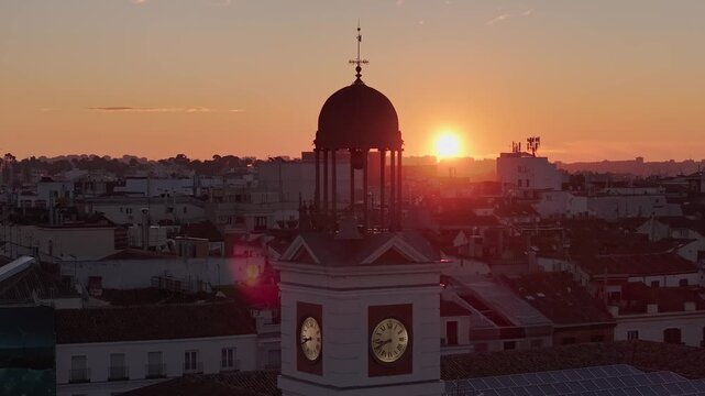 Aerial view of the clock tower in Puerta del Sol, a majestic stone structure, bathed in the warm glow of the setting sun, Madrid, Puerta del Sol, Spain.