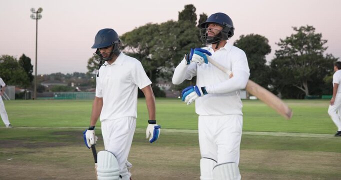 Crossing bats tapping gloves Diverse male cricketers walking pitch signaling end via fist bumping