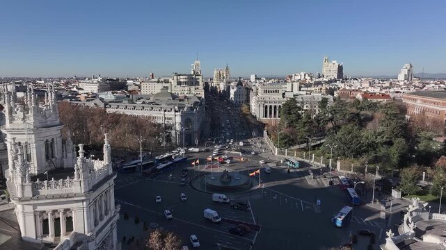 Aerial view of the intricate Cibeles Fountain as traffic flows around it, contrasting against the surrounding buildings, Madrid, Comunidad de Madrid, Spain.