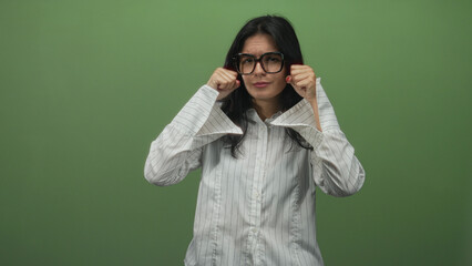 Young hispanic woman wearing oversized glasses and striped shirt makes crying gesture with hands in...