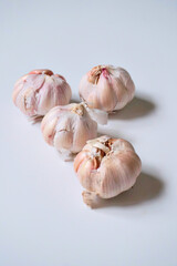 Four garlic cloves on a white background