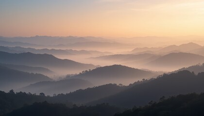 Wide panoramic view of misty mountain range with layered hills and soft morning sunrise light