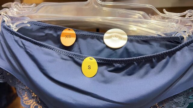 Horizontal video close up. Blue panties with tag S, XS size designation in female retail lingerie store. Concept of Black Friday sale, 11 november, buying clothes, shop, retail, fashion, oversize