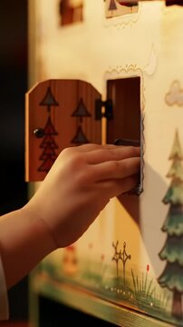 A childs curious hand opens a tiny door on a festive advent calendar, revealing a delicious piece of chocolate, celebrating the anticipation of Christmas.