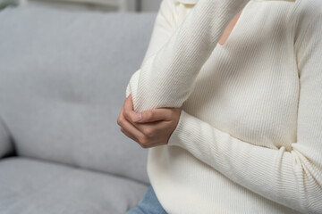 woman holding on elbow and while and suffer from unbearable pain health and problems, chronic...