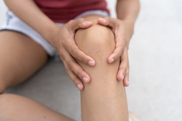 Asia female athlete or spot woman having knee injury due to ligament inflammation, knee pain due to exercise, massage, muscle relaxation, rheumatoid arthritis, gait disturbance, rheumatoid arthritis