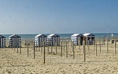 Row of white and blue beach huts the typical beach equipment of the Belgian coast at De Panne, Belgium.