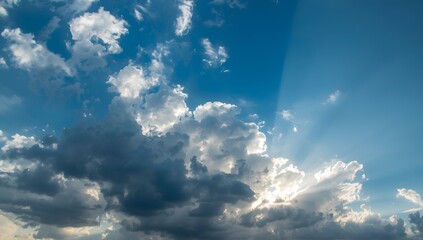Dramatic cumulonimbus clouds with sunlight breaking through creating a heavenly sky scene with rays of light illuminating the atmosphere