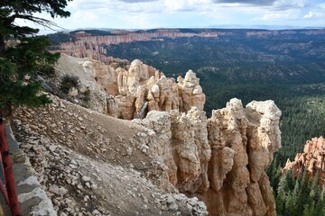 Scenic view of Bryce Canyon National Park's rock formations and forest under a partly cloudy sky.