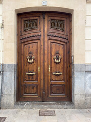 Elegant Wooden Double Doors with Ornate Design and Brass Doorknobs
