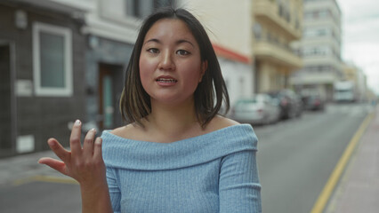 Young woman smiling on city street with modern buildings around in an urban setting, captured...