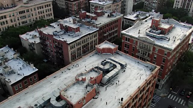 City rooftops show ducts, vents, and buildings, viewed from above