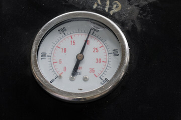 Pressure gauge or manometer on isolated black background, showing 300 PSI. mechanical installation...