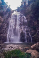 Waterfall falling from the rocks and trees around it in middle of forest and mountain in Jijel, Algeria, Africa, Beautiful waterfall for landscape, River waterfall, rain water and stream, water fall.