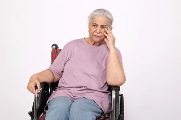 Portraits of a Sad unhealthy senior disabled woman sitting |in a wheelchair isolated white studio...
