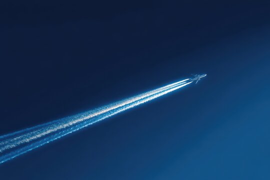 Jet Light Trails. Blue Jet Plane High in the Sky with Stunning Contrails