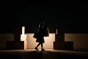 Empty boxes and a woman carrying them while moving is a casual aesthetic with very dim lighting.