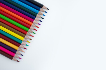 Colorful array of colored pencils arranged neatly on white background, showcasing vibrant hues for...