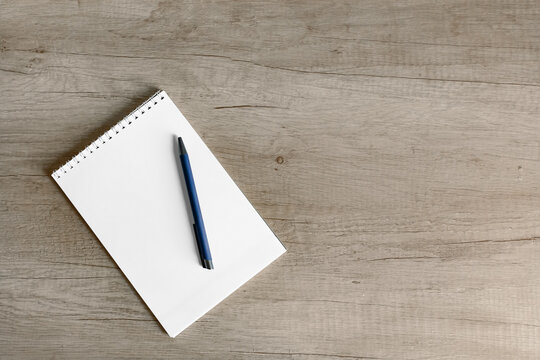 Creative morning setup with notepad and pen on rustic wooden table - Powered by Adobe