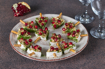 Brie cheese with pomegranate and walnuts in the shape of Christmas trees