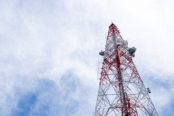 Low-angle view of a red and white telecommunications tower structure against a bright sky, highlighting modern engineering, symmetry, and industrial design.