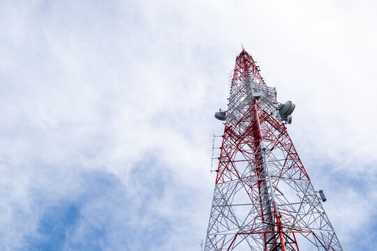Low-angle view of a red and white telecommunications tower structure against a bright sky, highlighting modern engineering, symmetry, and industrial design. - Powered by Adobe