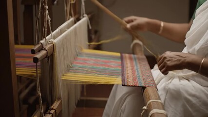 Artisan Weaving Traditional Textile on Loom - Close-up shot of a weaver's hands skillfully operating a traditional loom, the shuttle moving rhythmically to create a vibrant textile.