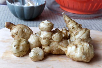 Fresh Jerusalem Artichokes on a Wooden Cutting Board in Natural Lighting