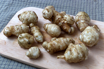 Fresh Jerusalem Artichokes on a Wooden Cutting Board in Natural Lighting