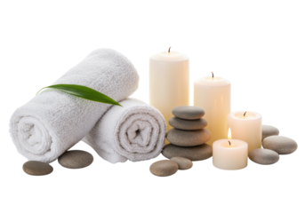 Two white terry cloth towels, one with a green leaf, smooth river pebbles, and three burning white candles, flat lay on a transparent background with soft shadows. Concept of spa and wellness
