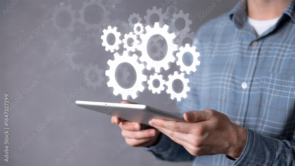 Poster man holding tablet with digital gears overlayed in front of a plain gray background
