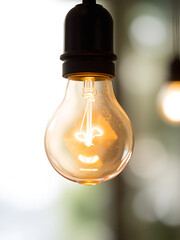 Glowing light bulb shines brightly against a blurred background