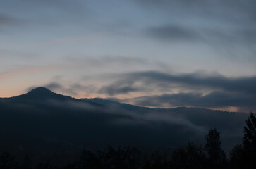 Smoky mountains against the backdrop of a blue morning sky with clouds. Sunrise.