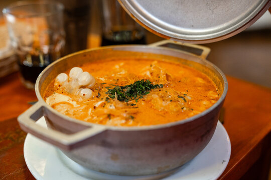 Traditionelle peruanische Suppe oder Eintopf serviert in einem Topf auf einem Holztisch