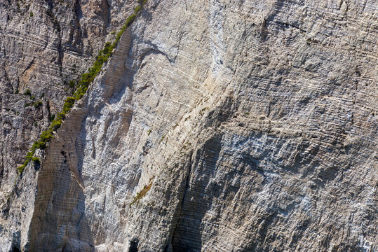 Rocky Cliff Face with Textured Layers and Vegetation