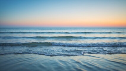 Obraz premium Sunset over the ocean with gentle waves and calm waters. Nature and scenery concept. Tranquility and peacefulness of a seaside landscape.