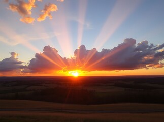 Fototapeta premium Sunset Sky Radiance: Capture the breathtaking majesty of a setting sun. The sky ignites with vibrant colors, as sunlight rays burst forth, creating an awe-inspiring view