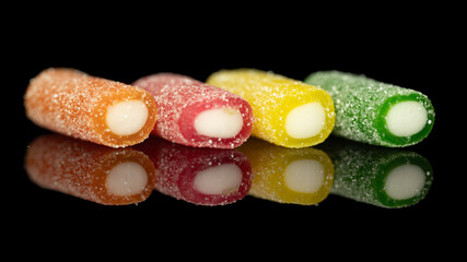 Colorful sugar-coated jelly candies with reflection on black background