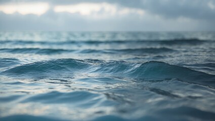 Fototapeta premium Waves on the ocean surface with a cloudy sky, serene seascape, outdoor nature scene, calm water, and open sea.