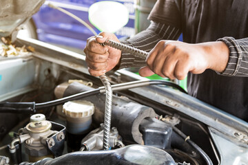Mechanic man with wrench repairing car at workshop