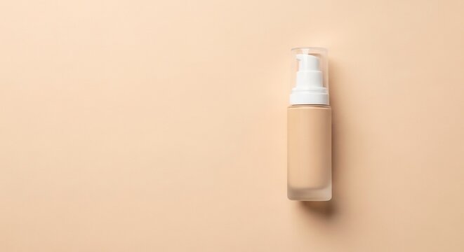 A bottle of liquid foundation makeup with a pump dispenser on a light beige background