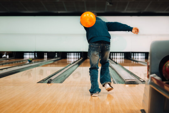 Teenage boy about to release ball while ten pin bowling