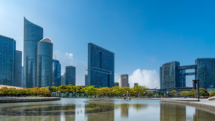 Fototapeta premium Modern Urban Skyline with Reflective Water Surface and Greenery