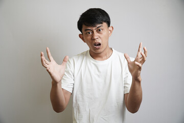 A frustrated young Asian man with an angry expression