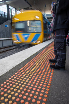 blurred Person standing on a train platform with a train arriving