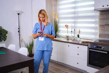 Female Doctor Using Smartphone at Home in her Kitchen