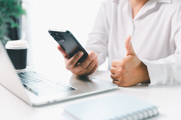 Close-up businesswoman using smart mobile phone at office table, female student is home studying...